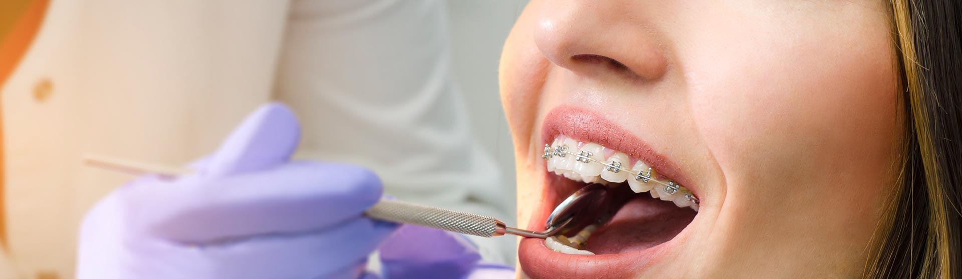 Dentist examining patient's orthodontics braces