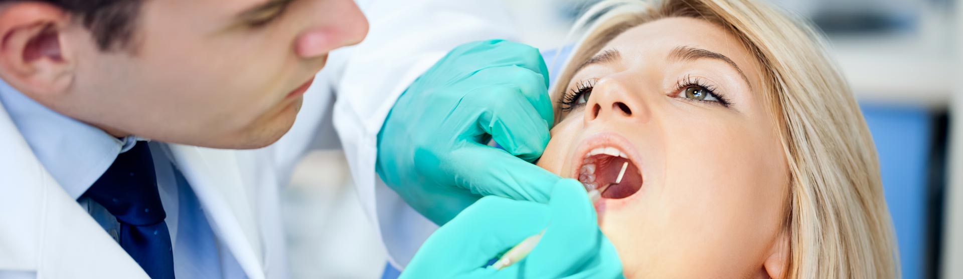 Dentist examining patient for oral cancer