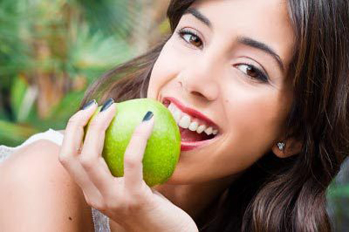 Young woman holding a green apple